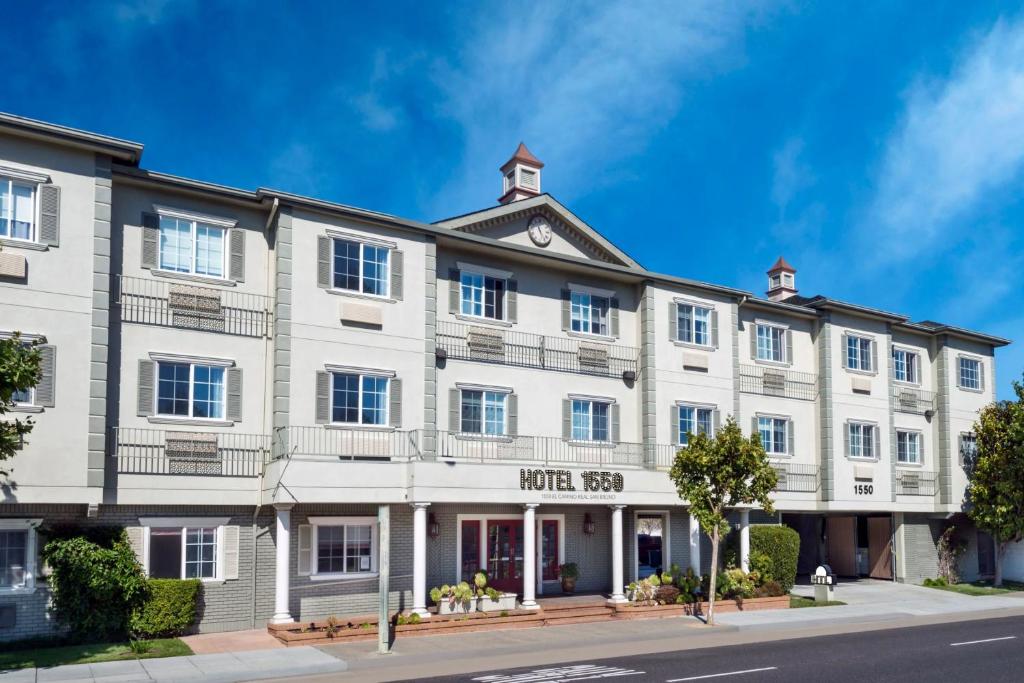 a large white building on a city street at Hotel 1550 - SFO Airport FREE Shuttle in San Bruno
