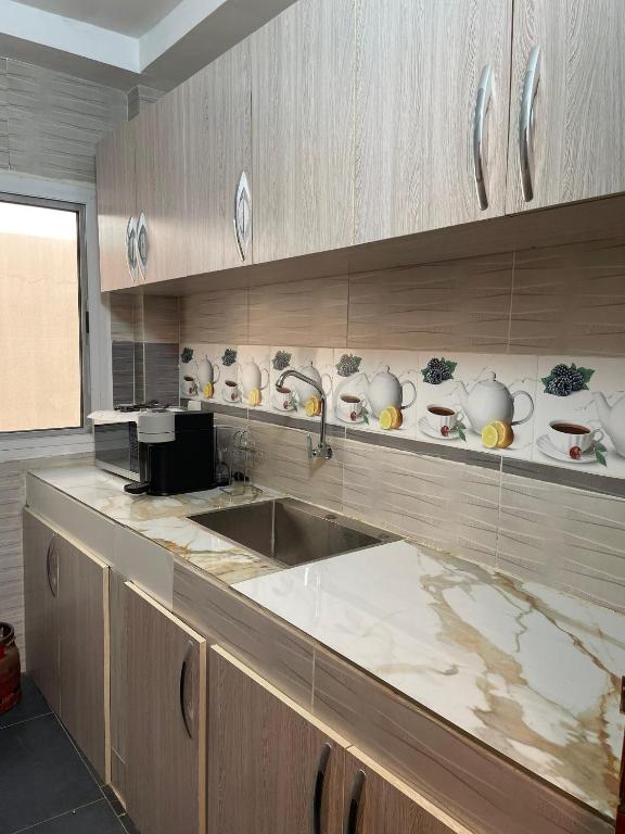 a kitchen with a counter with bowls and plates on the shelf at You Royal in Dakar