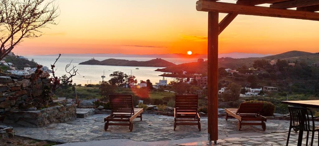 Eine Gruppe von Stühlen sitzt auf einer Terrasse im Sonnenuntergang. in der Unterkunft Marvia Studios in Vourkari