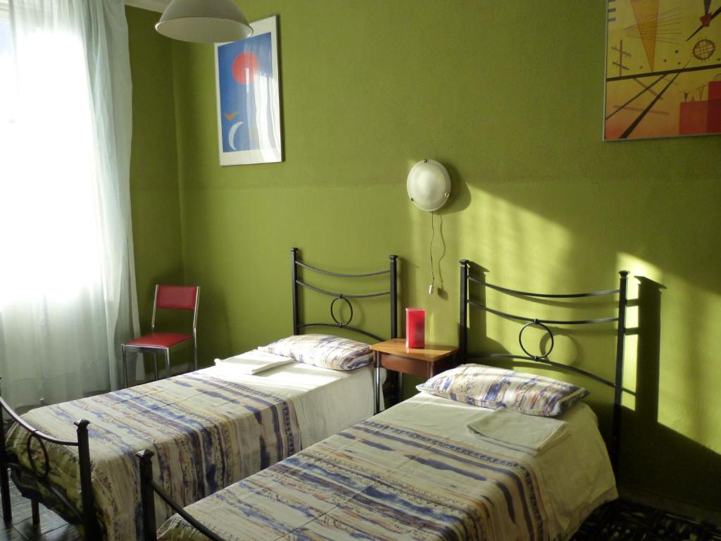 two beds in a room with green walls at Hotel Giamaica for Girls & Ladies Only in Rome