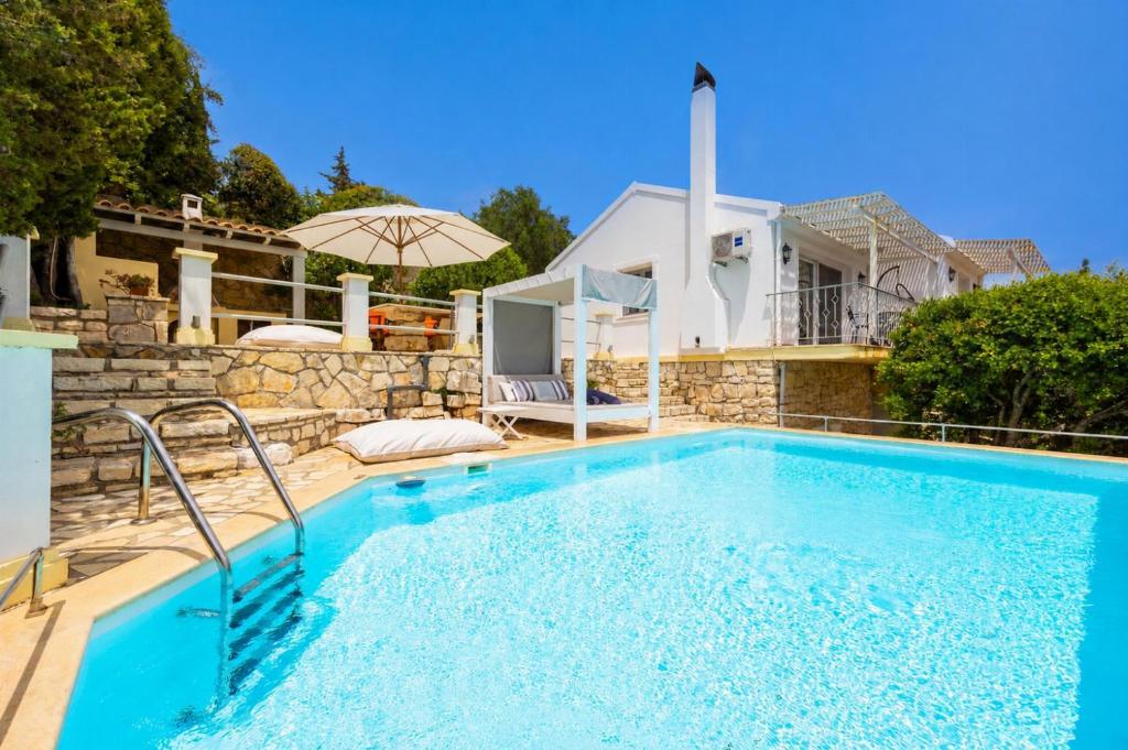 a swimming pool in front of a villa at Villa Gardenia in Vlachopoulátika