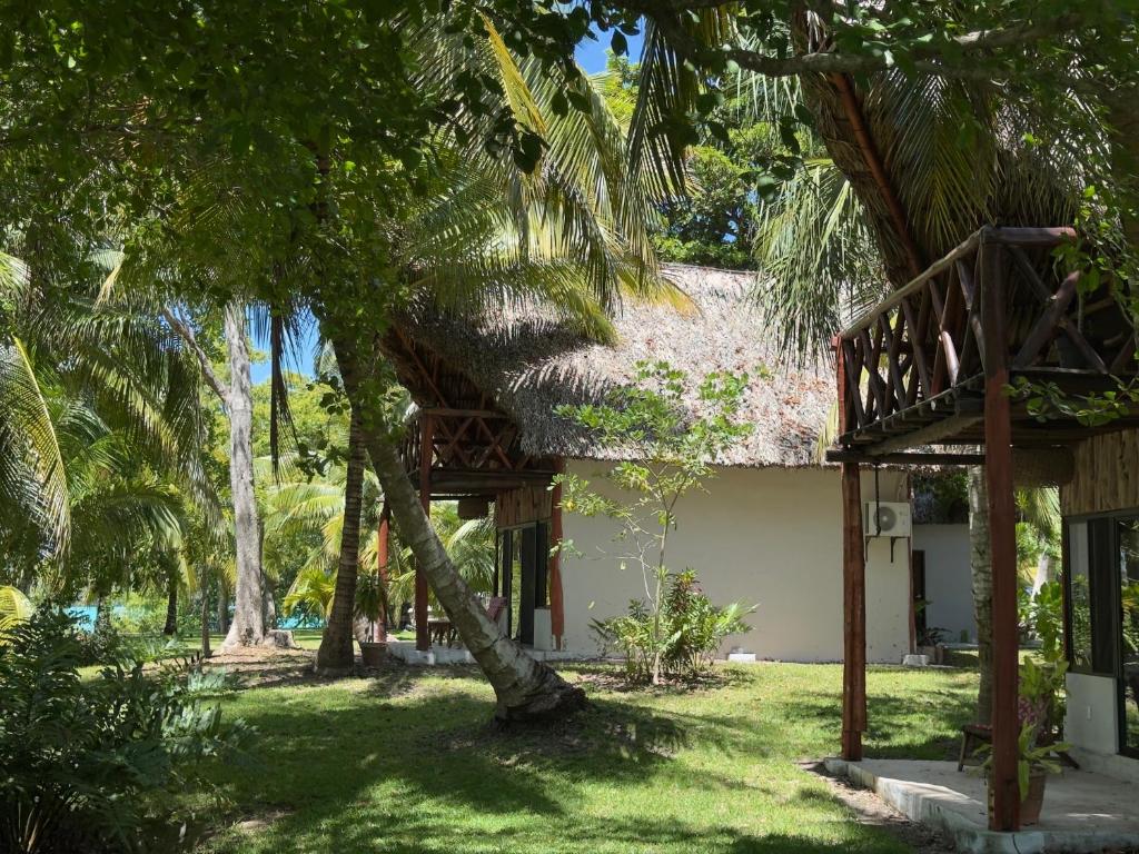 a house with a thatched roof and a balcony at Xanthus Hotel in Huay Pix