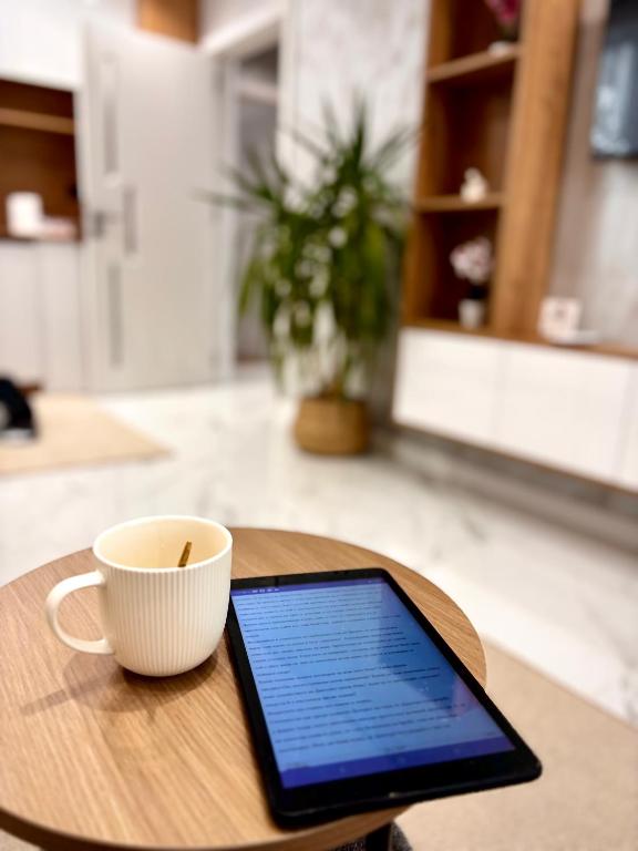 a tablet and a cup on a wooden table at Arena Apartment in Gotse Delchev