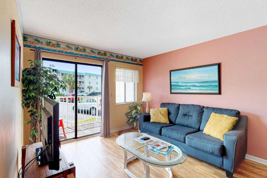 a living room with a blue couch and a tv at Plantation East #3117 in Gulf Highlands