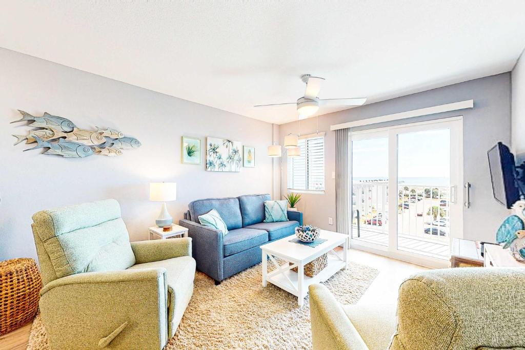a living room with a blue couch and a chair at Plantation East #4504 in Gulf Highlands