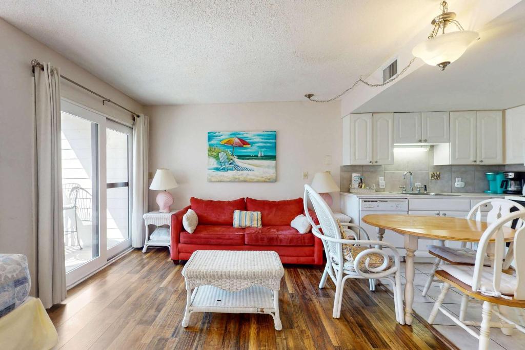 a living room with a red couch and a table at Plantation West #1261 in Gulf Highlands