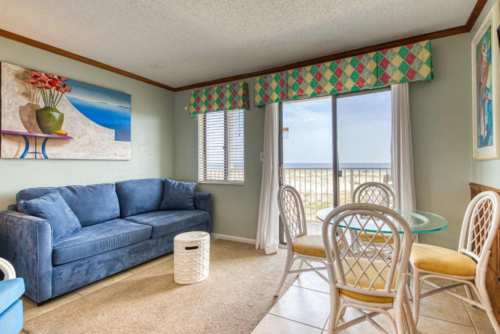 a living room with a blue couch and a table and chairs at Plantation East #1201 in Gulf Highlands