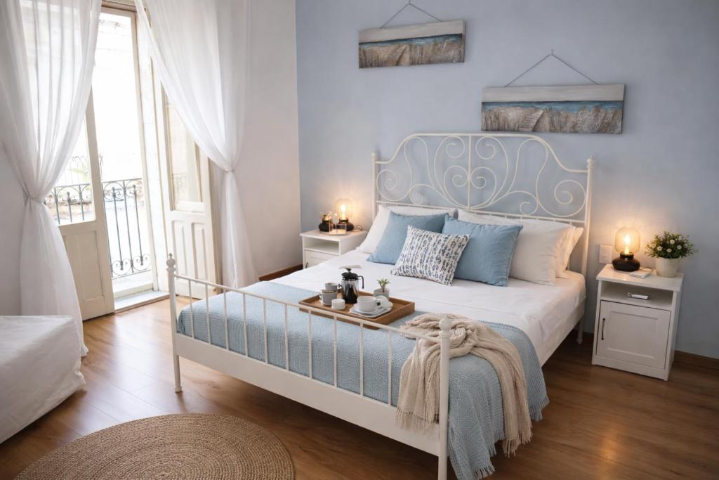 a bedroom with a large bed with a blue headboard at Lùrooms- Guesthouse in Noto in Noto