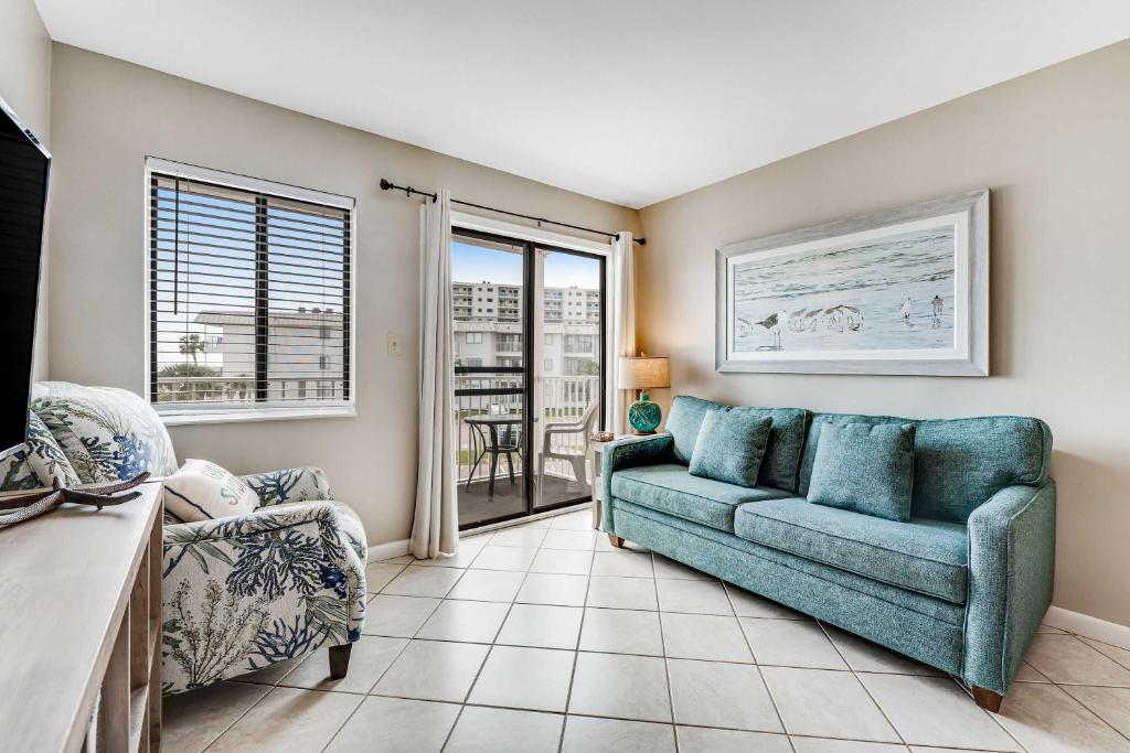 a living room with a couch and a chair at Condo by the beach with Gulf views plus shared pool in Fort Morgan