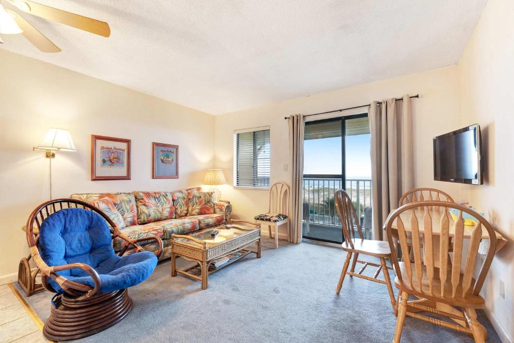 a living room with a couch and chairs and a tv at Waterfront Gulf condo with beach access shared pool in Fort Morgan