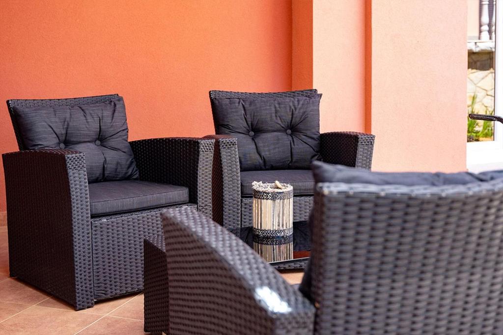 two wicker chairs and chairs in a room at Apartments Mistral in Lopar