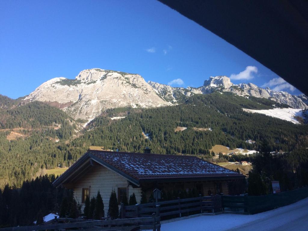 un edificio con montañas cubiertas de nieve en el fondo en Annaberg en Annaberg im Lammertal