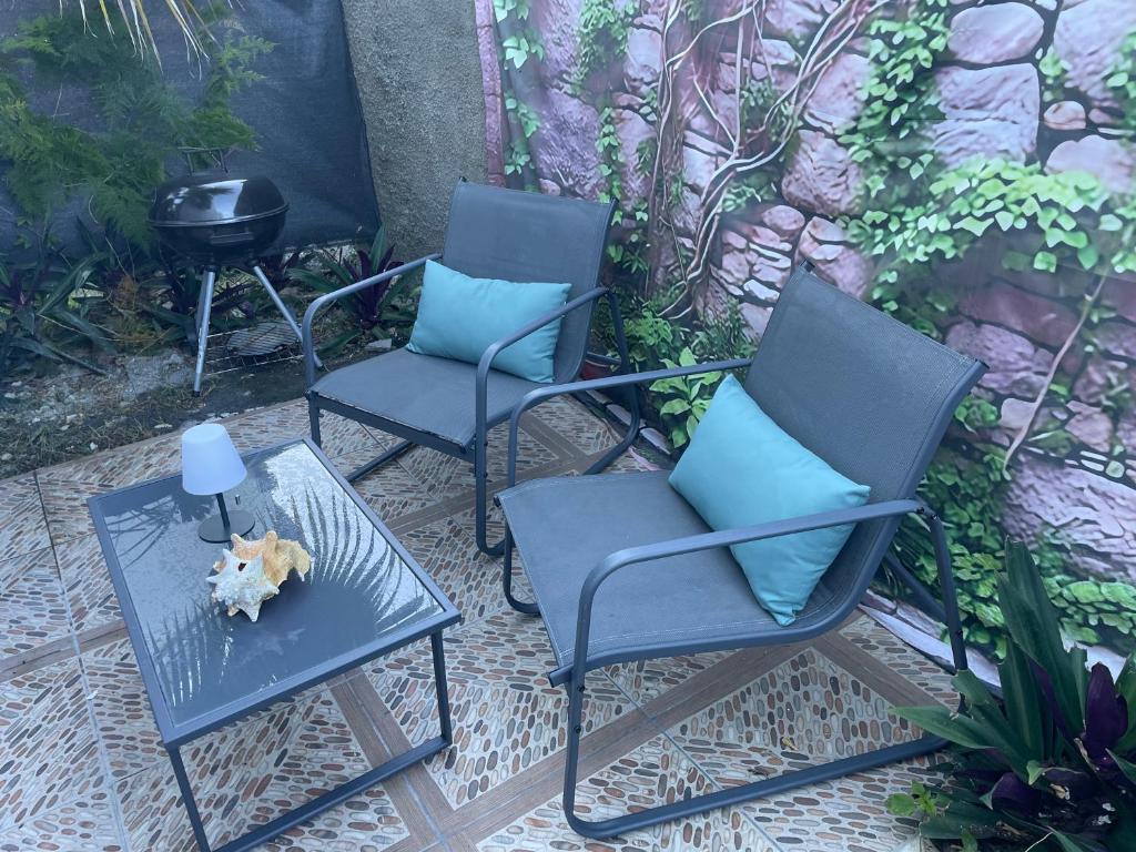a group of three chairs and a table with a fire place at Ti kaz a fredo in Port-Louis