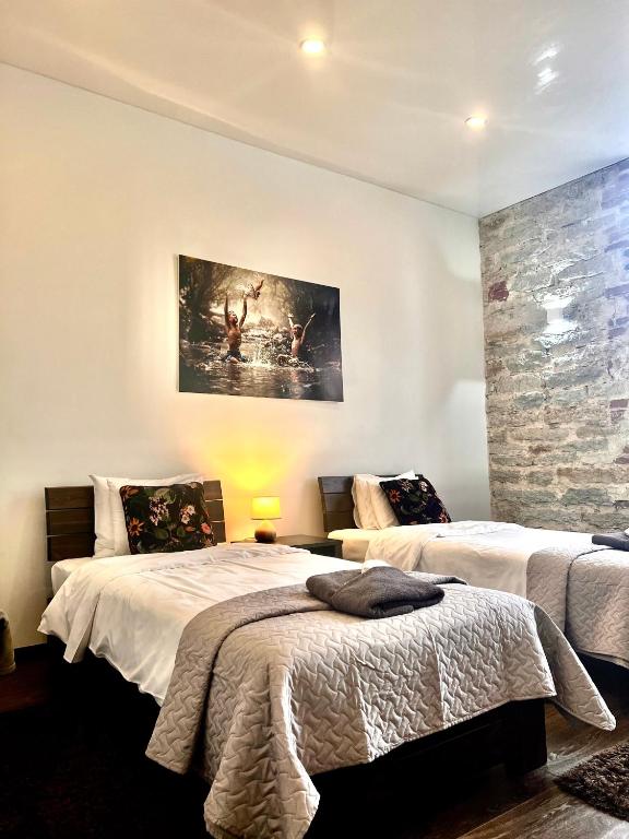 ein Schlafzimmer mit zwei Betten und einem Gemälde an der Wand in der Unterkunft Vabriku 6 Apartment with sauna in Rakvere