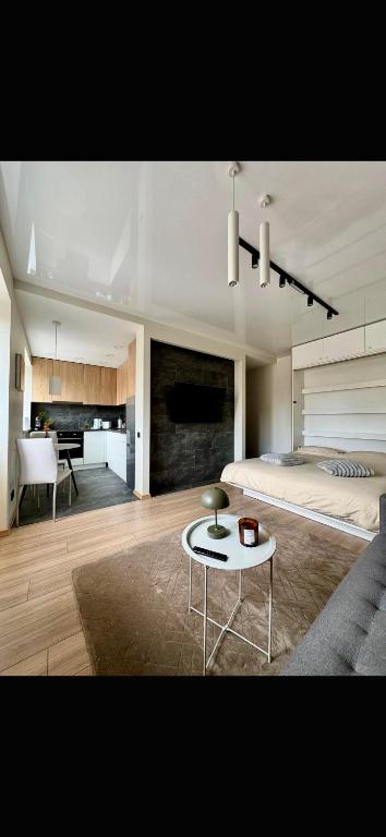 a bedroom with a bed and a table in a room at Sandstone Residence - Modern Apartment - 5 min Walk to Beach in Liepāja
