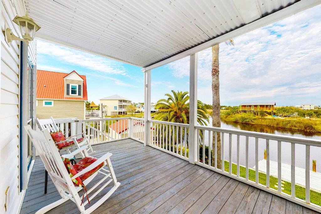 a porch with a rocking chair and a view of the water at Beach Haven by Meyer Vacation Rentals in Gulf Shores