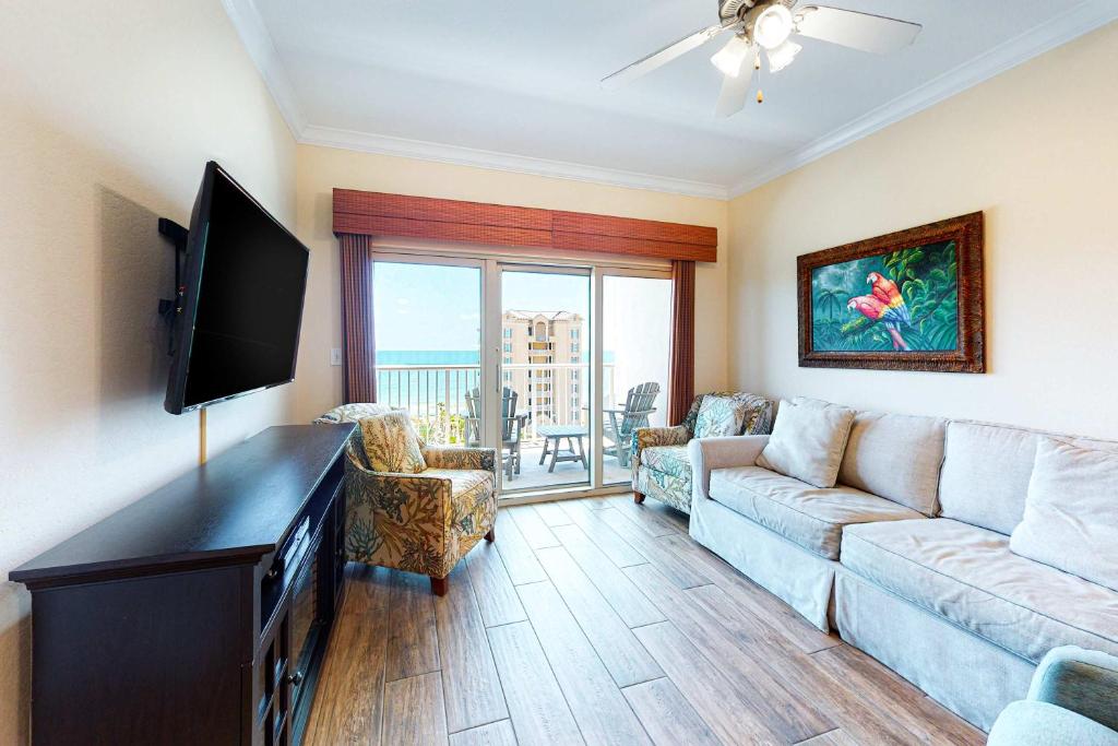 a living room with a couch and a flat screen tv at Crystal Tower 705 in Gulf Shores
