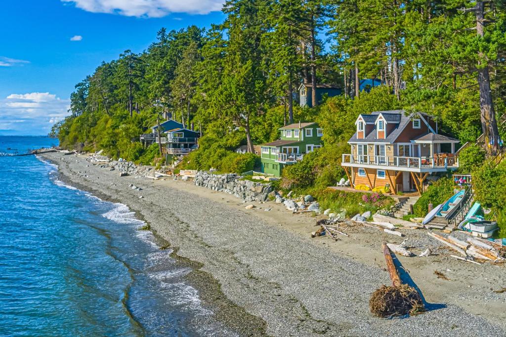 a row of houses on the shore of a beach at 2BR Beachfront Cottage w/ Grill & Expansive Deck in Point Roberts
