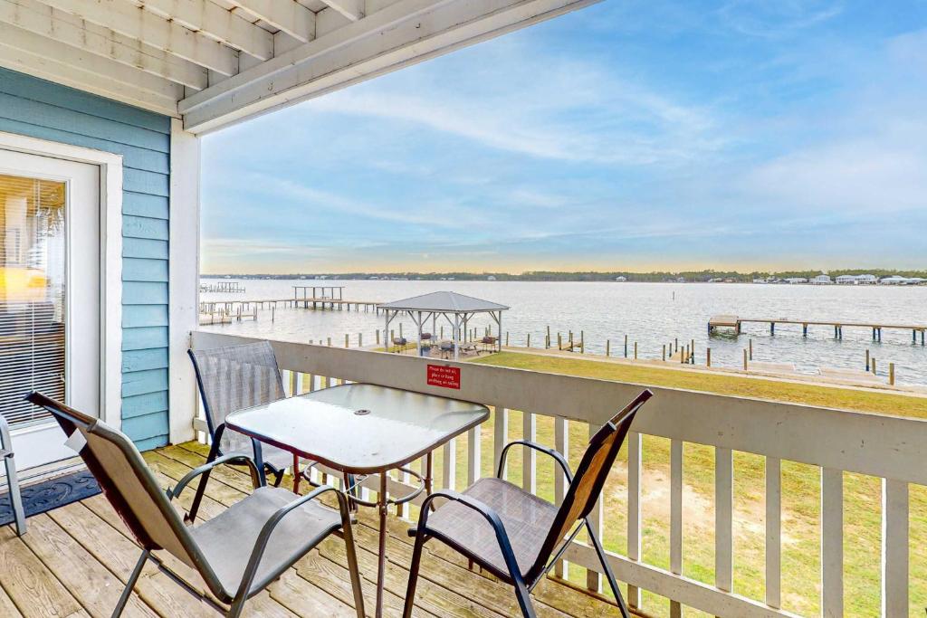 a balcony with chairs and a table and a view of the water at Sea Oats E106 in Gulf Shores