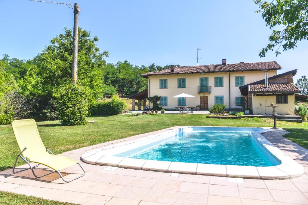 a pool with a chair and a house at Relax Cascina Lissona in Sessant