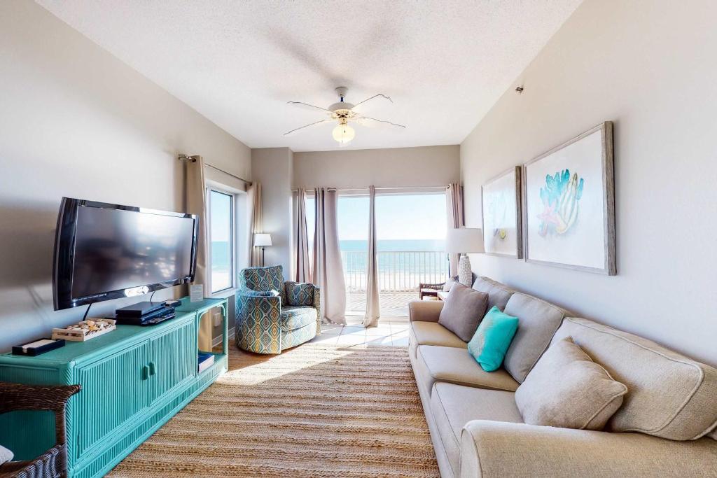 a living room with a couch and a flat screen tv at Tidewater 601 in Orange Beach