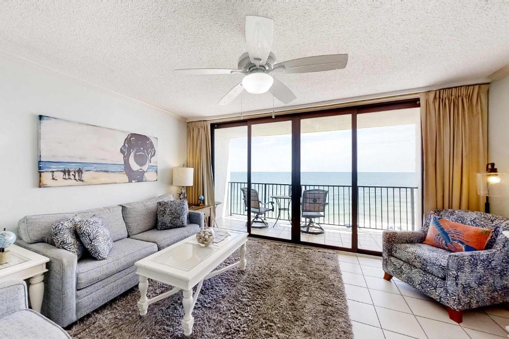 a living room with a couch and a view of the ocean at Beachfront Condo with Gorgeous Gulf View Balcony & Shared Pools in Orange Beach