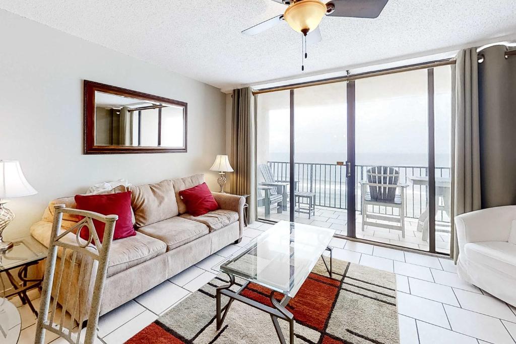 a living room with a couch and a glass table at Beachfront Condo with Gulf View Balcony WiFi AC & Shared Pools in Orange Beach