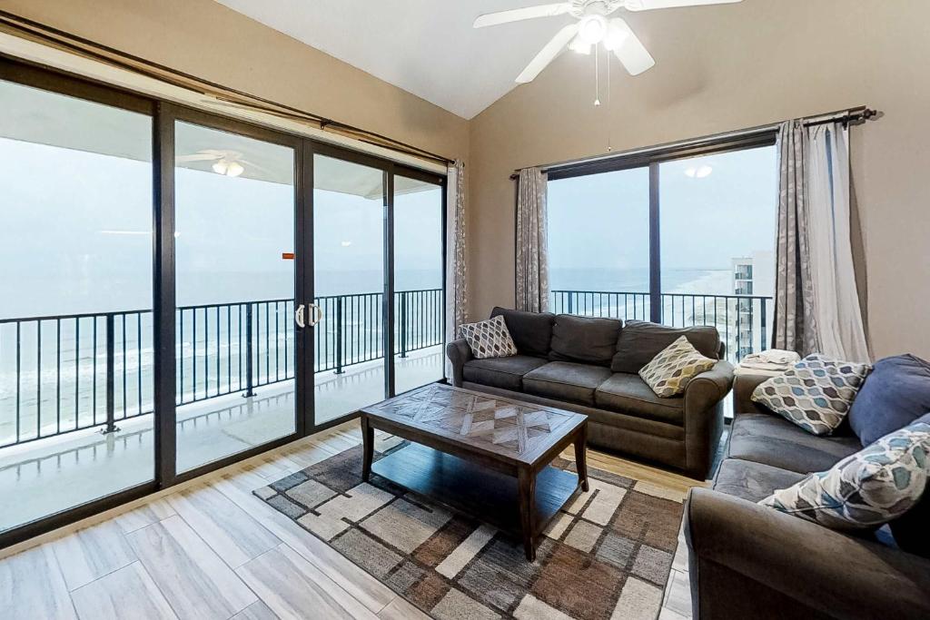 a living room with a couch and a table at Gulf-front corner condo with wraparound balcony pools beach access in Orange Beach