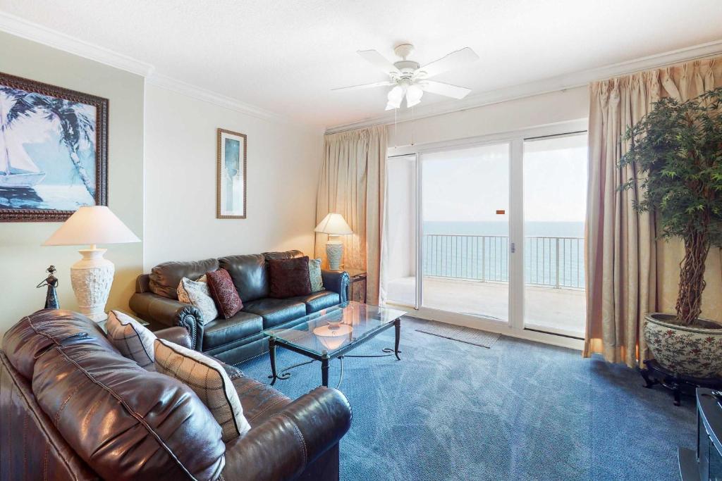 a living room with a leather couch and a view of the ocean at Regency Isle 805 in Orange Beach