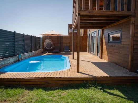 a swimming pool on a wooden deck next to a house at Villa Maris in Demre