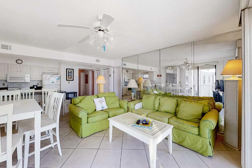 a living room with a green couch and a table at Fantastic condo with elevator WiFi & central AC - beachfront Location in Orange Beach