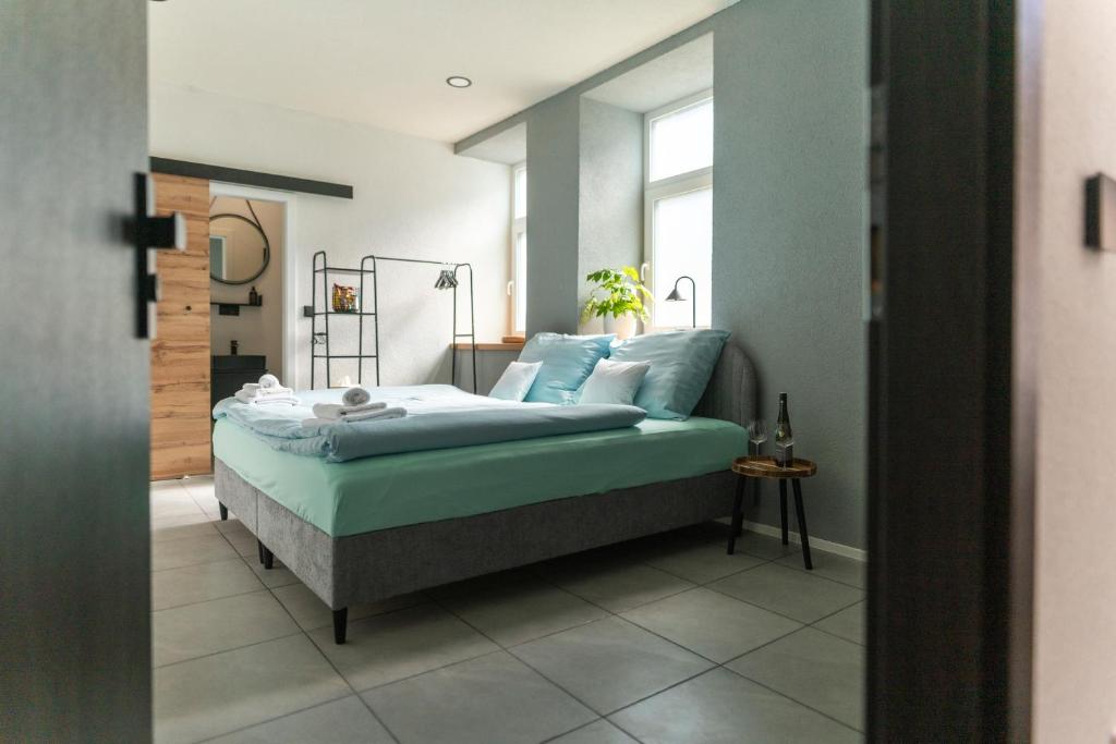 a bedroom with a bed with blue sheets and a window at Rezidence 14 Nový Bor in Nový Bor