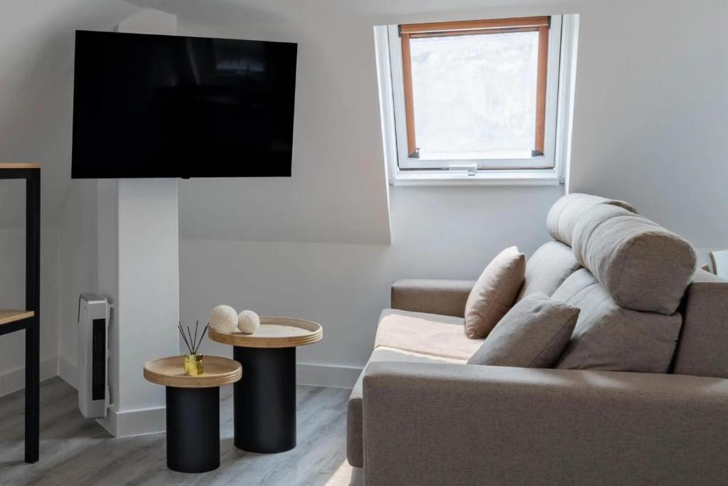 a living room with a couch and a flat screen tv at A Casita do Muelle in Cambados