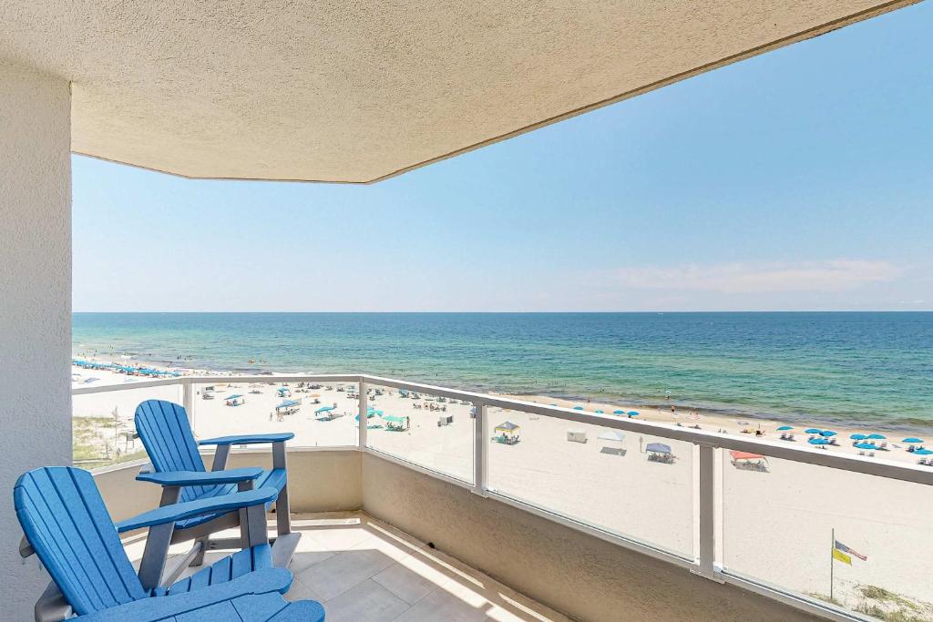 two blue chairs on a balcony overlooking the beach at Silver Beach 601 in Orange Beach