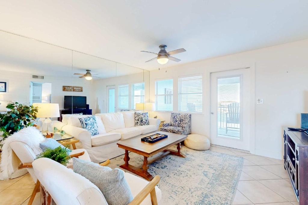 a living room with a white couch and a table at Jubilee Landing 302 in Orange Beach