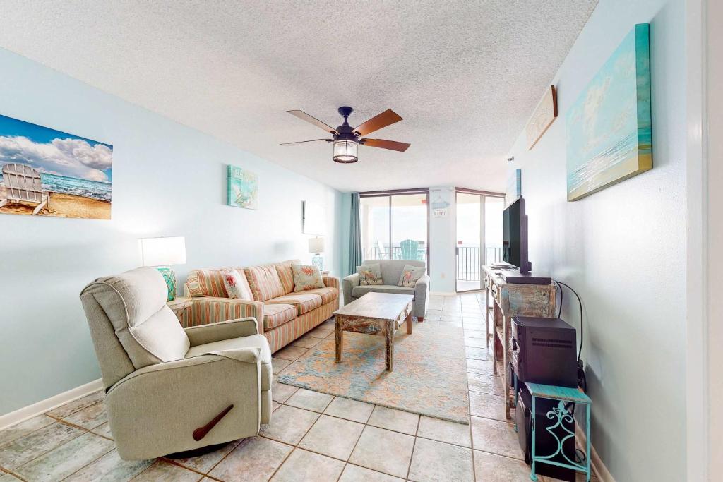a living room with a couch and a tv at Phoenix East 702 in Orange Beach
