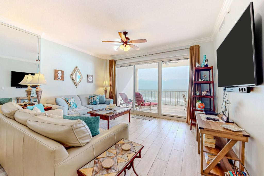 a living room with a couch and a flat screen tv at Regency Isle 611 in Orange Beach