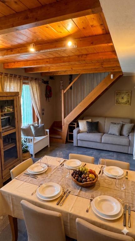 a table with plates and a bowl of fruit on it at Duplex Esclusivo Bardonecchia - Centro - Garage in Bardonecchia