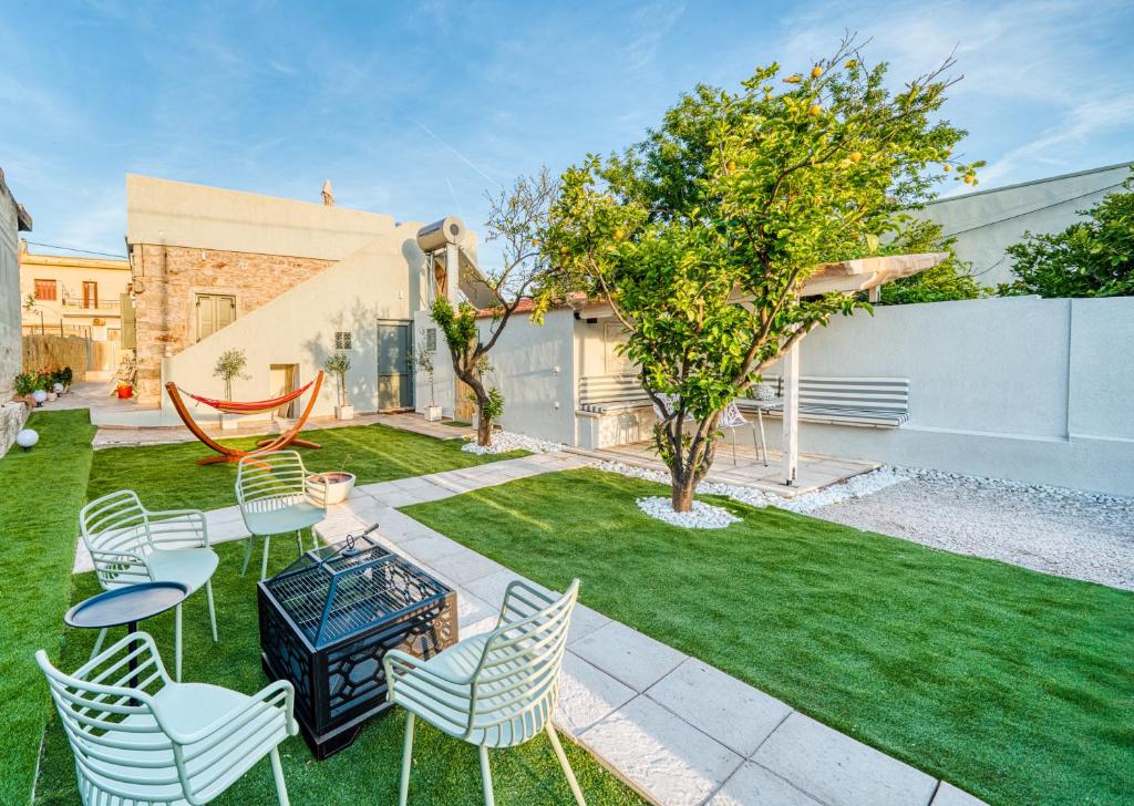 a backyard with chairs and a table and a lawn at Kalamoti Suites in Kalamoti