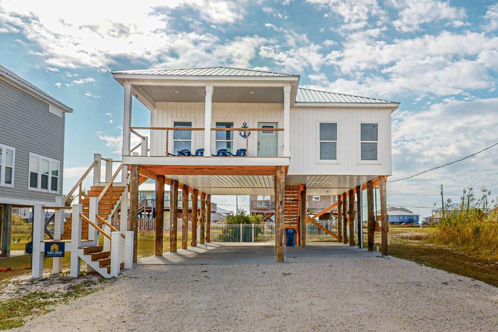 a house on a wooden structure with a deck at The Anchor Holds in Dauphin Island