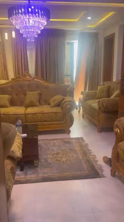 a living room with couches and a chandelier at Yaba Elite Stays in Lagos