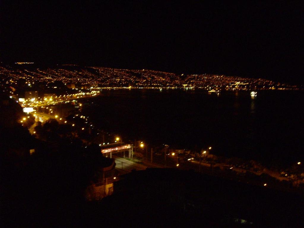 vista di una città di notte con l'oceano di Excelente Vista a la Bahía de Valparaíso a Valparaíso