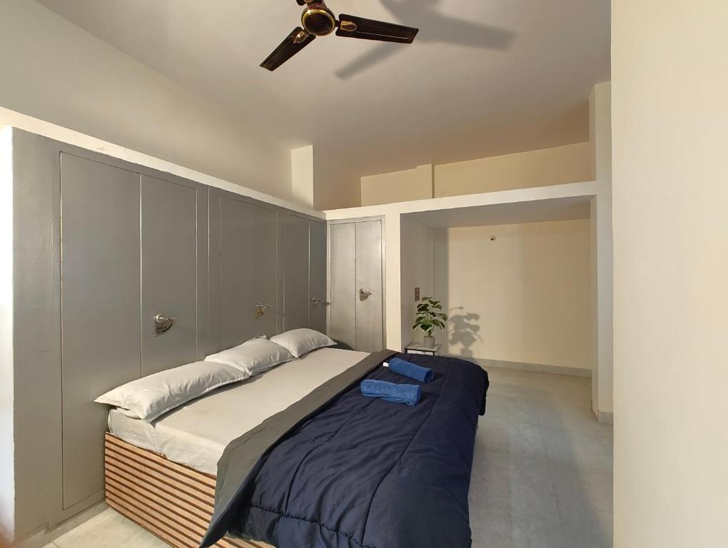 a bedroom with a bed with a ceiling fan at Galaxy Homestay 4Bhk AC in Mysore