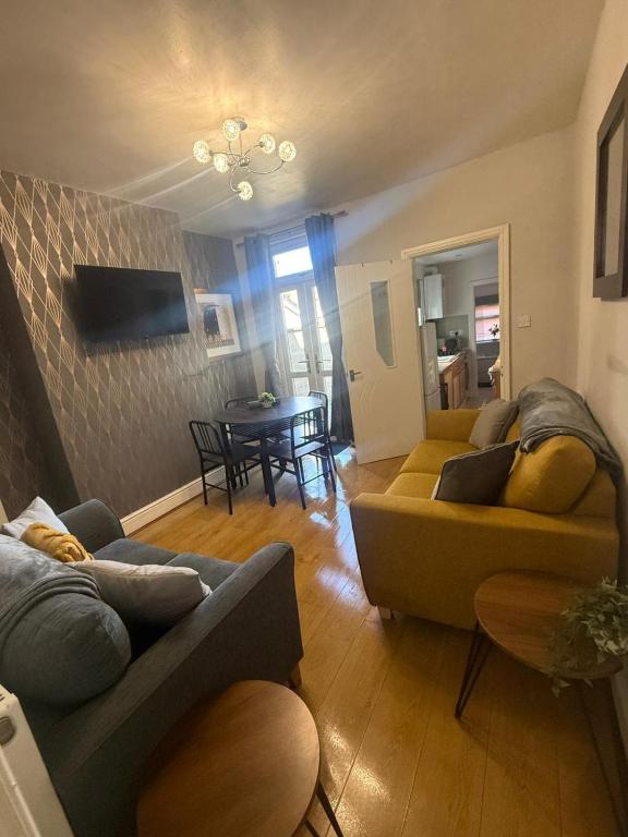 a living room with two couches and a table at Anglesey House in Burton upon Trent