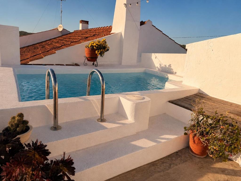a white house with a swimming pool next to a building at Encanto do frade in Carrapatelo