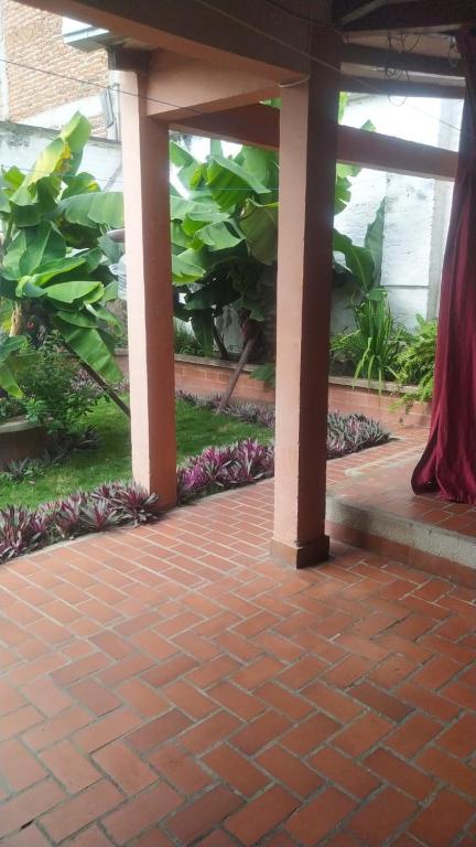 a brick patio with plants in a building at Hotel casa inglesa in Buga