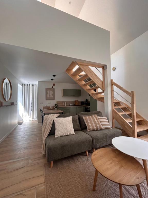 a living room with a couch and a staircase at Ker Rev Home Gîte indépendant de charme en longère bretonne in Quimper