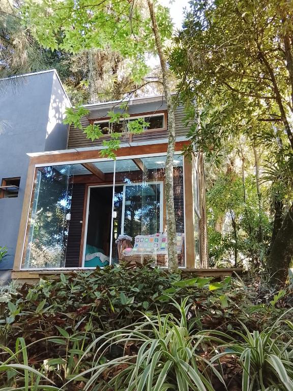 a small house with a window in the woods at Tiny House II - experiência de refúgio exclusivo in Gravataí