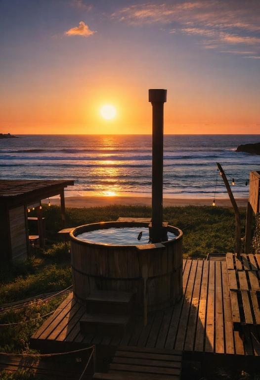 a hot tub with the sunset in the background at Tinaja en la playa para 2 in Matanzas