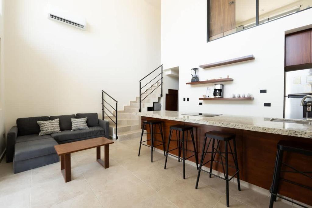 a kitchen and living room with a couch and a bar at Modern 2BR Condo Close to Downtown Cabo in Cabo San Lucas